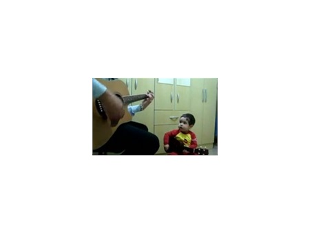 Em bé dễ thương ôm guitar hát theo bố