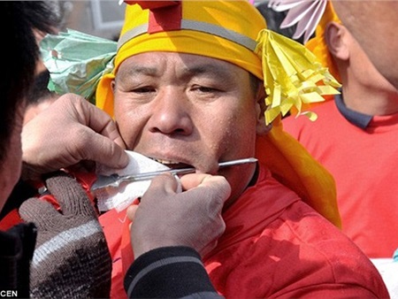 Dùng thanh kim loại đâm xuyên má trong lễ hội đặc biệt ở Trung Quốc