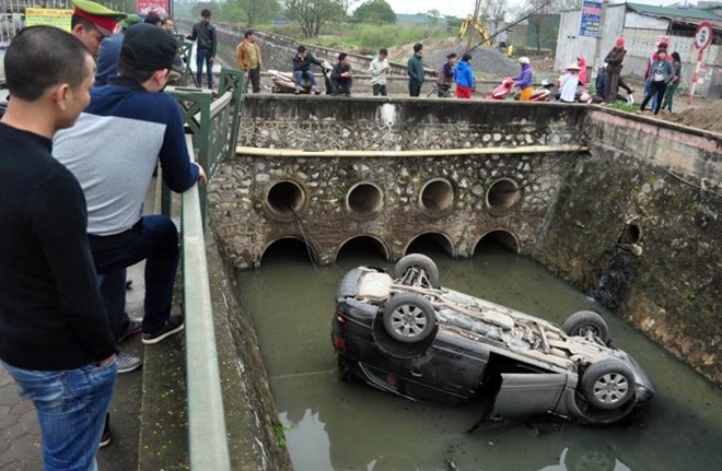 Audi Q7 lật ngửa dưới mương nước hôi thối