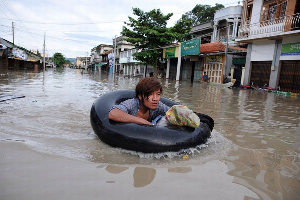 Hình ảnh phóng viên đằm mình dưới dòng nước lũ để đưa tin gây sốt
